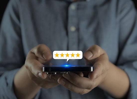 Person holding phone with 5 stars above phone