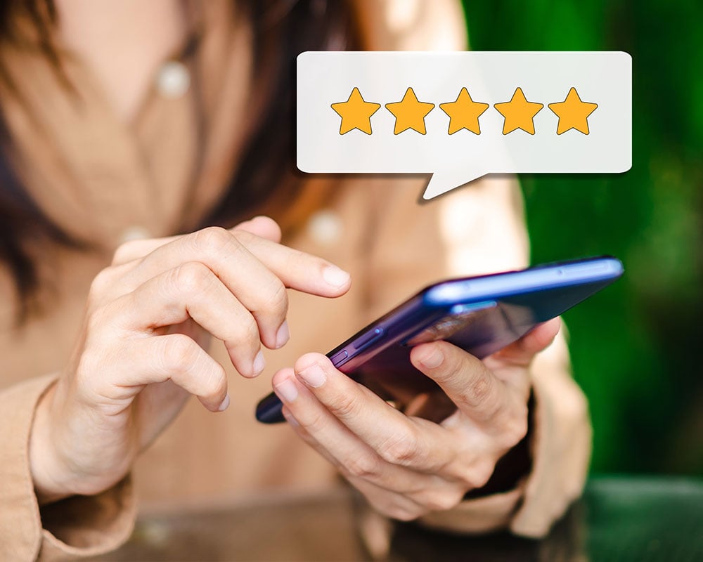 5 Star review above person holding phone