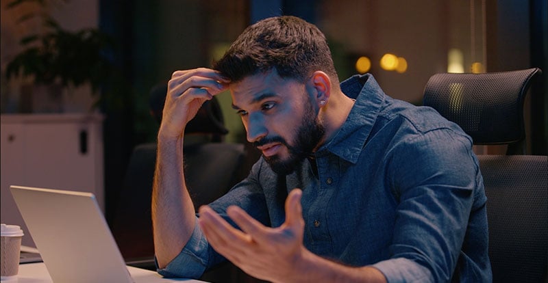 Frustrated man sitting in front of computer